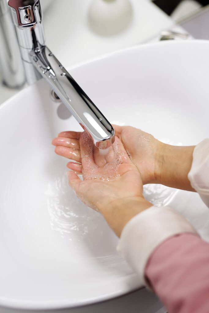 En person som tvättar händerna under rinnande vatten